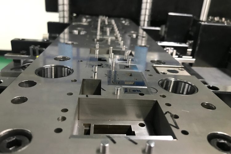 Progressive die stamping of copper strip for electrical contact production
