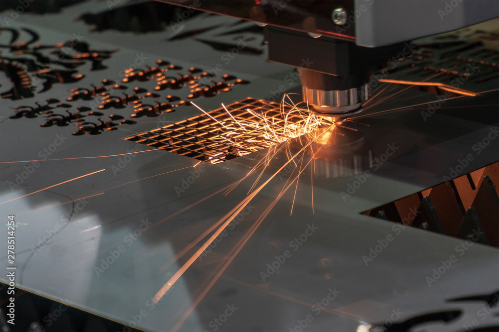Fiber laser cutting machine processing sheet metal in a manufacturing facility
